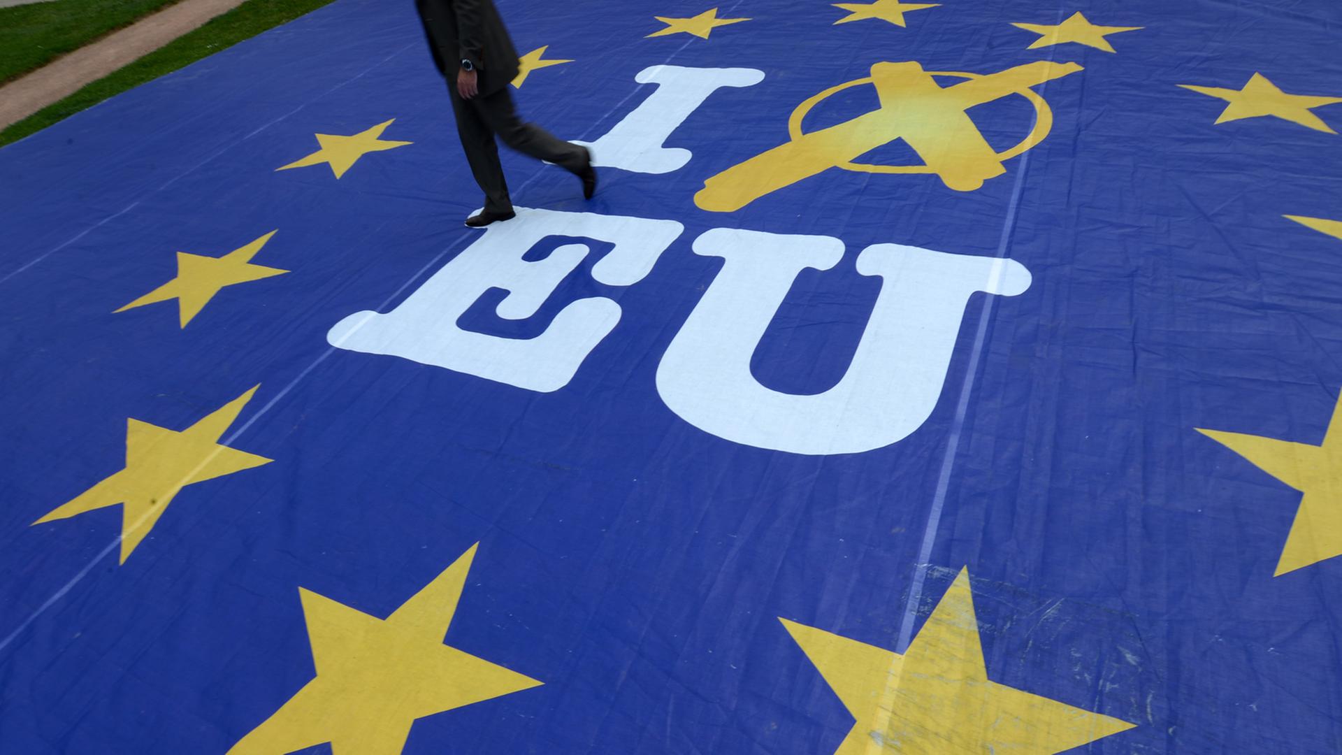 Ein Mann geht am 21.05.2014 in Wiesbaden (Hessen) über ein Aktionsbanner mit der Aufschrift "I vote EU". Ein Mann geht am 21.05.2014 in Wiesbaden (Hessen) über ein Aktionsbanner mit der Aufschrift "I vote EU".