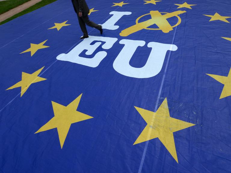 Ein Mann geht am 21.05.2014 in Wiesbaden (Hessen) über ein Aktionsbanner mit der Aufschrift "I vote EU".