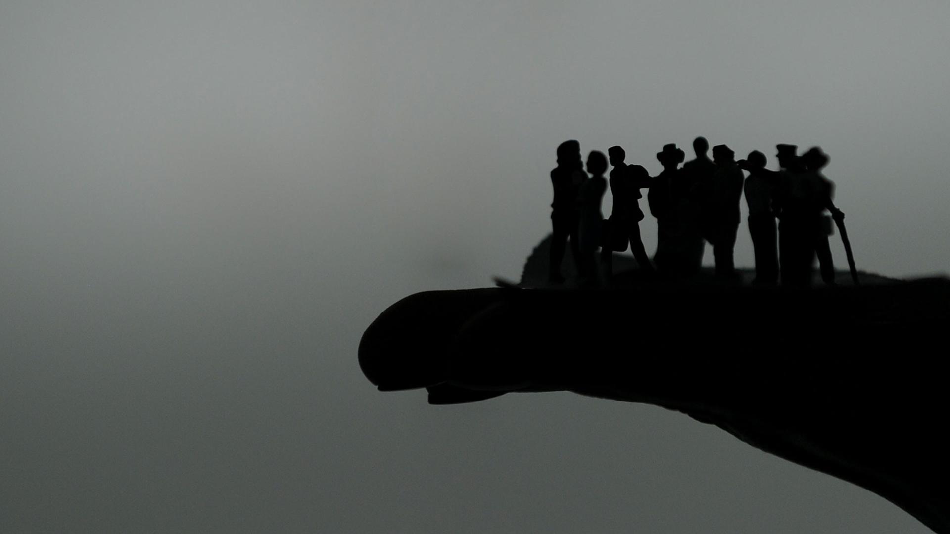 Die Silhouetten von Figuren auf einer Hand. Die Silhouetten von Figuren auf einer Hand.