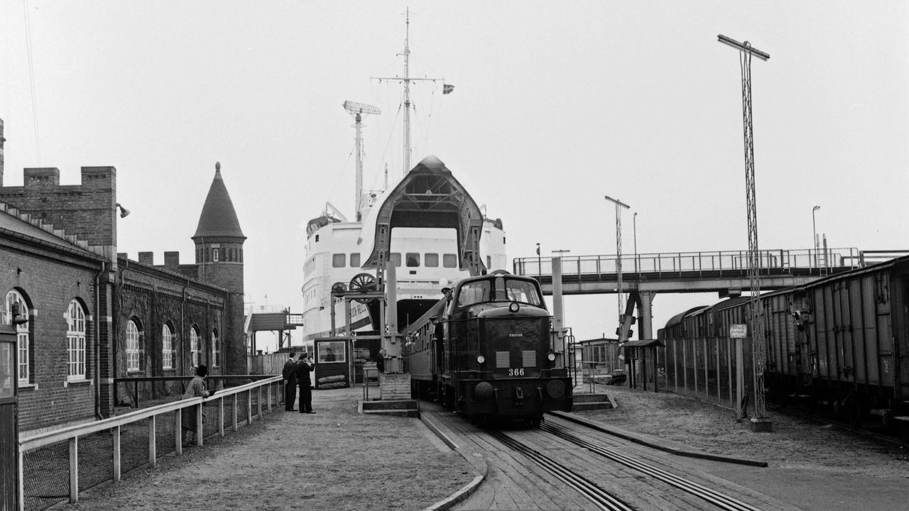 Schwarz-weiß Foto, auf dem ein Zug die Fähre verlässt im Hafen von Puttgarden auf der Insel Fehmarn in den 1960er Jahren. Schwarz-weiß Foto, auf dem ein Zug die Fähre verlässt im Hafen von Puttgarden auf der Insel Fehmarn in den 1960er Jahren.