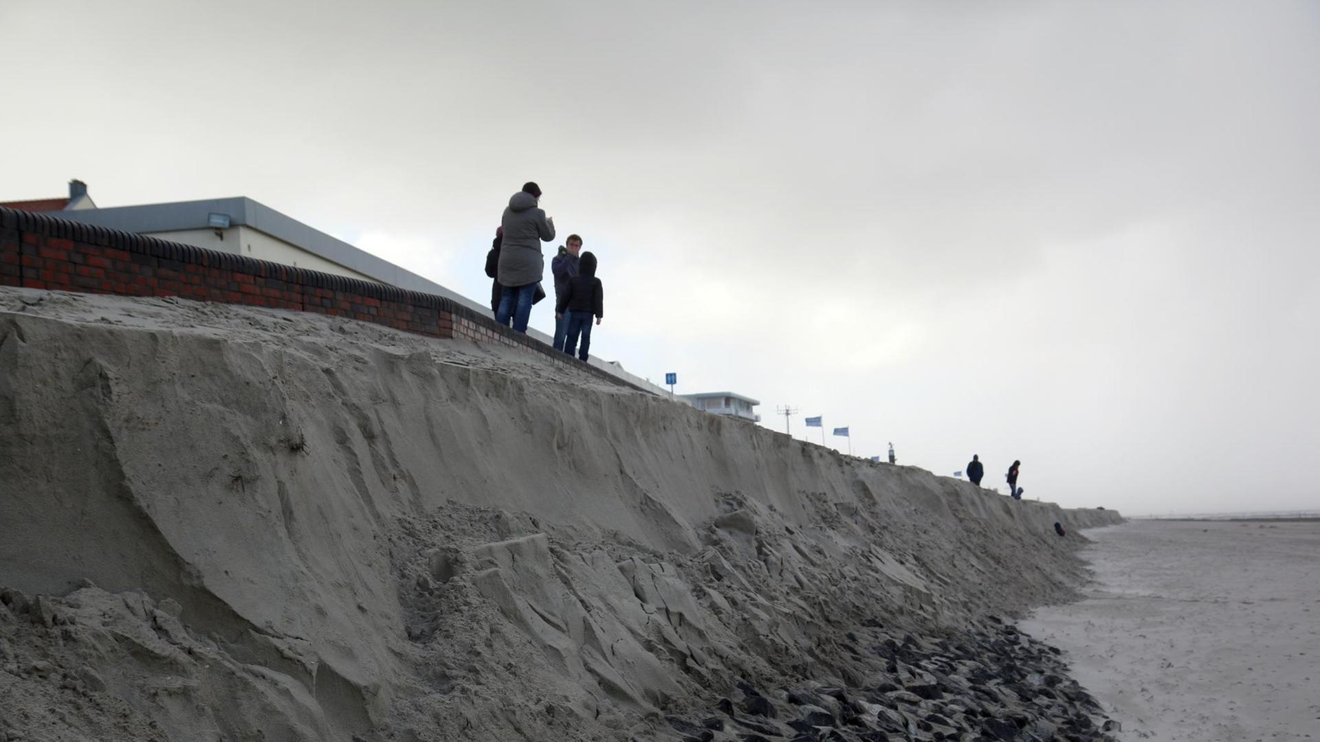 Das Bild zeigt Passanten, die am 29.10.2017 an der Abbruchkante im Mittelfeld des Bade- und Burgenstrandes auf Wangerooge stehen. Das Bild zeigt Passanten, die am 29.10.2017 an der Abbruchkante im Mittelfeld des Bade- und Burgenstrandes auf Wangerooge stehen.