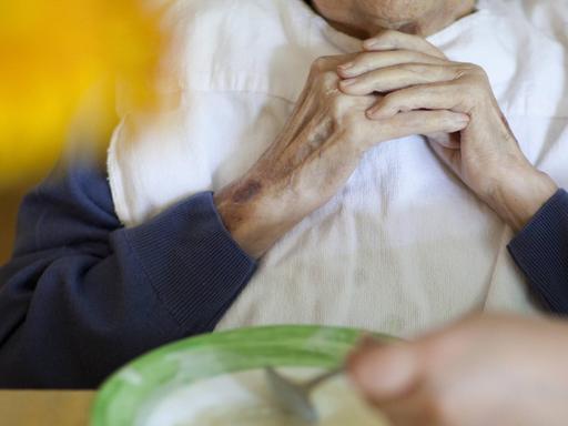 Eine alte Frau beim Essen in einem Altenpflegeheim