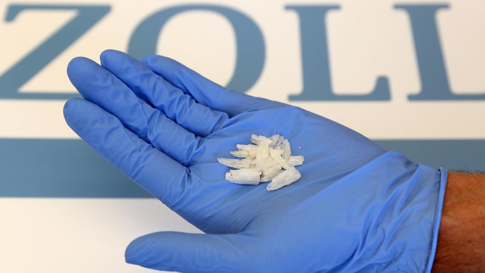 Eine Hand mit Handschuh mit Crystal Meth. Eine Hand mit Handschuh mit Crystal Meth.