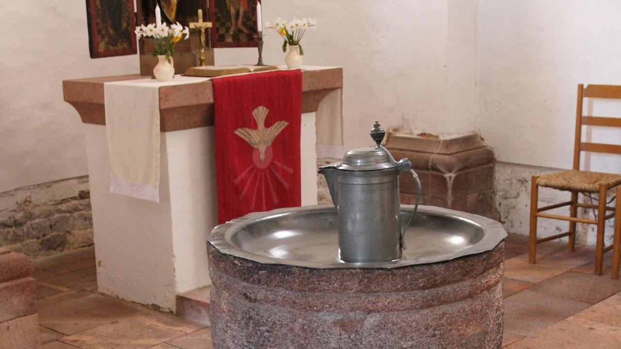 Eine romanische Porphyr-Taufe in Kelchform aus dem 12. Jahrhundert in der evangelischen Kilianskirche in Bad Lausick in Sachsen. Die Kirche wurde als dreischiffige romanische Pfeilerbasilika nach 1105 errichtet. Eine romanische Porphyr-Taufe in Kelchform aus dem 12. Jahrhundert in der evangelischen Kilianskirche in Bad Lausick in Sachsen. Die Kirche wurde als dreischiffige romanische Pfeilerbasilika nach 1105 errichtet.