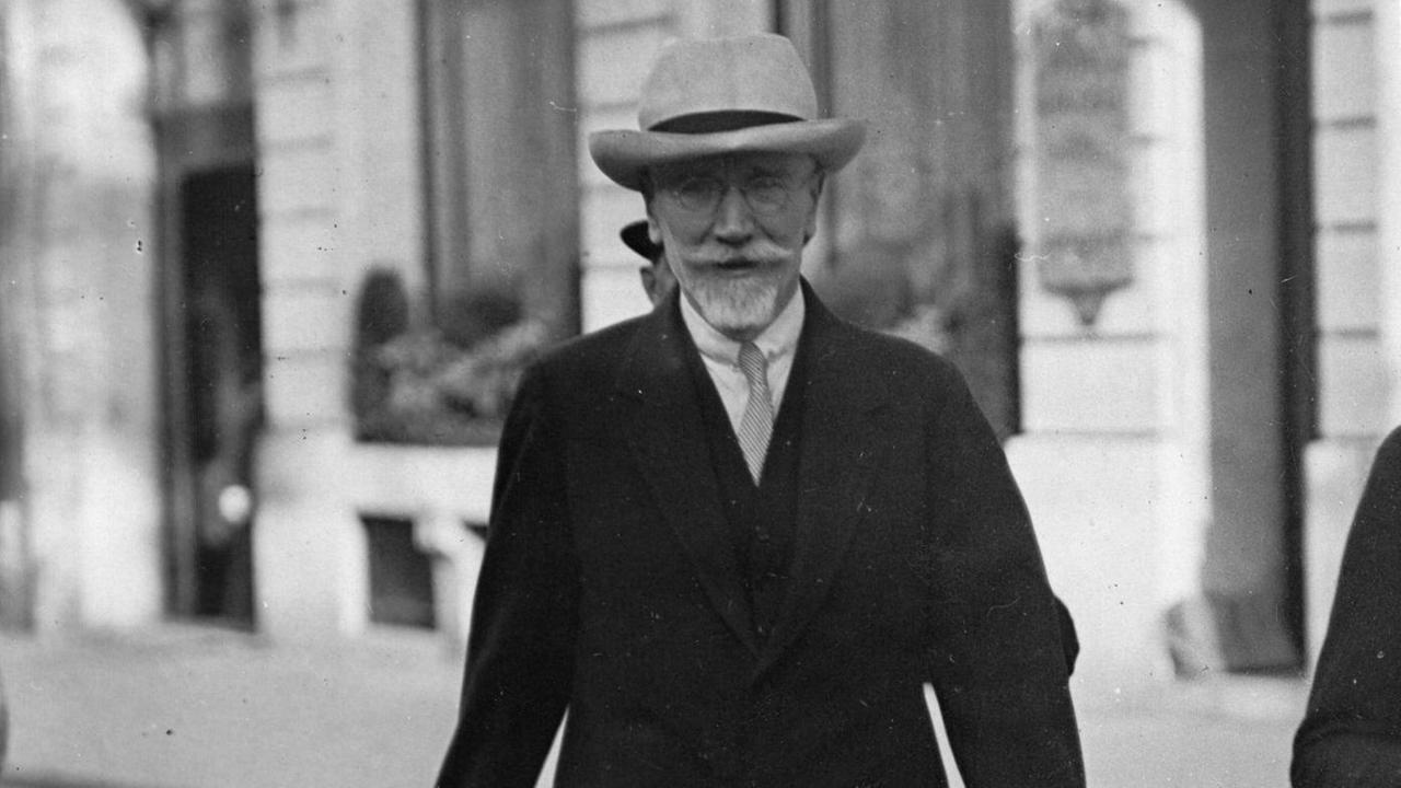 Eleftherios Venizelos trägt Hut, Bart und einen Anzug und läuft auf einer Straße. (Historische schwarzweiß Fotografie) Eleftherios Venizelos trägt Hut, Bart und einen Anzug und läuft auf einer Straße. (Historische schwarzweiß Fotografie)