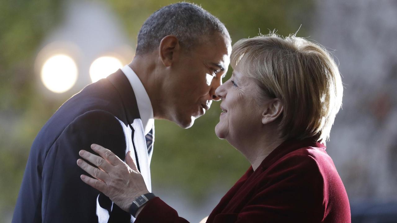 Barack Obama und Angela Merkel begrüßen sich mit Wangenküsschen.