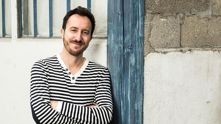 Der Ensembleleiter und Countertenor Damien Guillon vor einer Wand Der Ensembleleiter und Countertenor Damien Guillon vor einer Wand