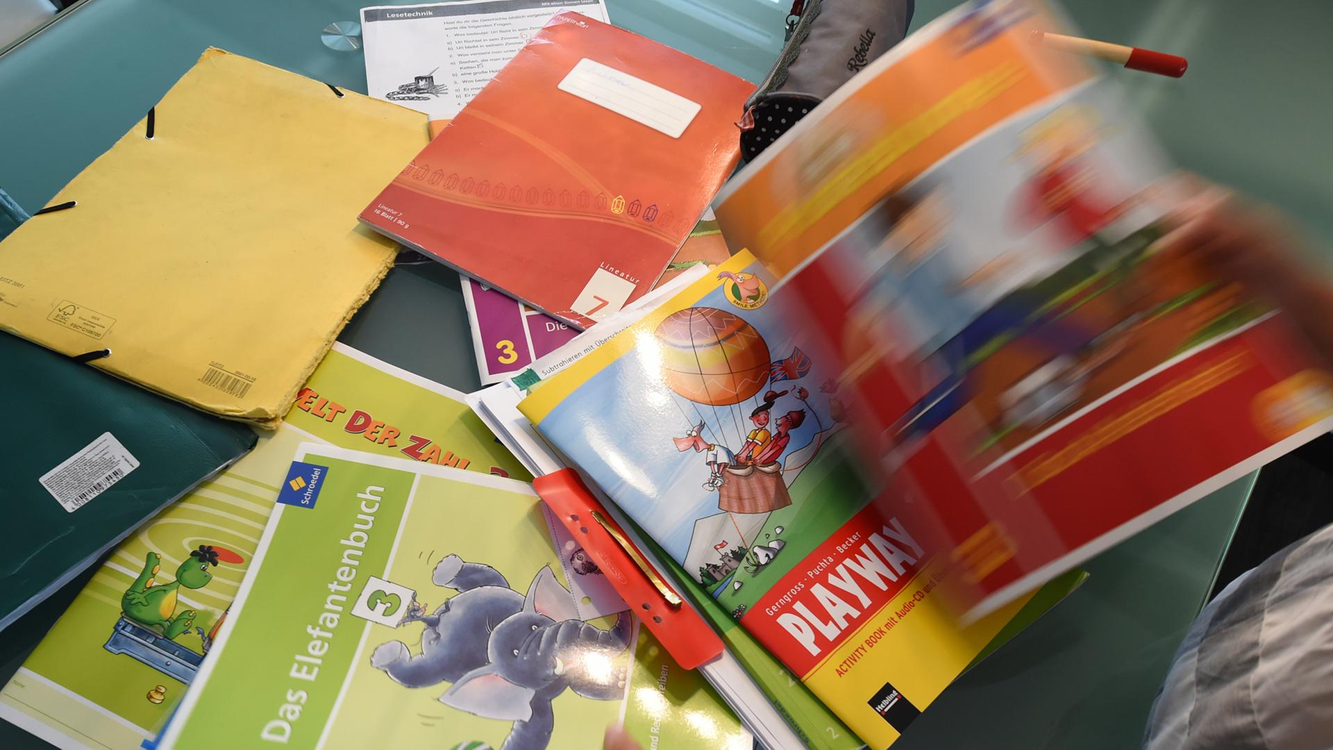 Eine Grundschülerin sortiert ihre Schulbücher Eine Grundschülerin sortiert ihre Schulbücher