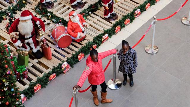 Eine Mall in Nairobi, mit Weihnachtsdekoration. Zwei Kinder stehen vor einer Absperrung.