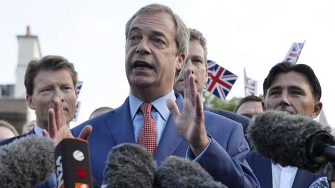 Nigel Farage bei einem Pressestatement umringt von Journalisten und Brexit-Befürwortern mit britischen Flaggen