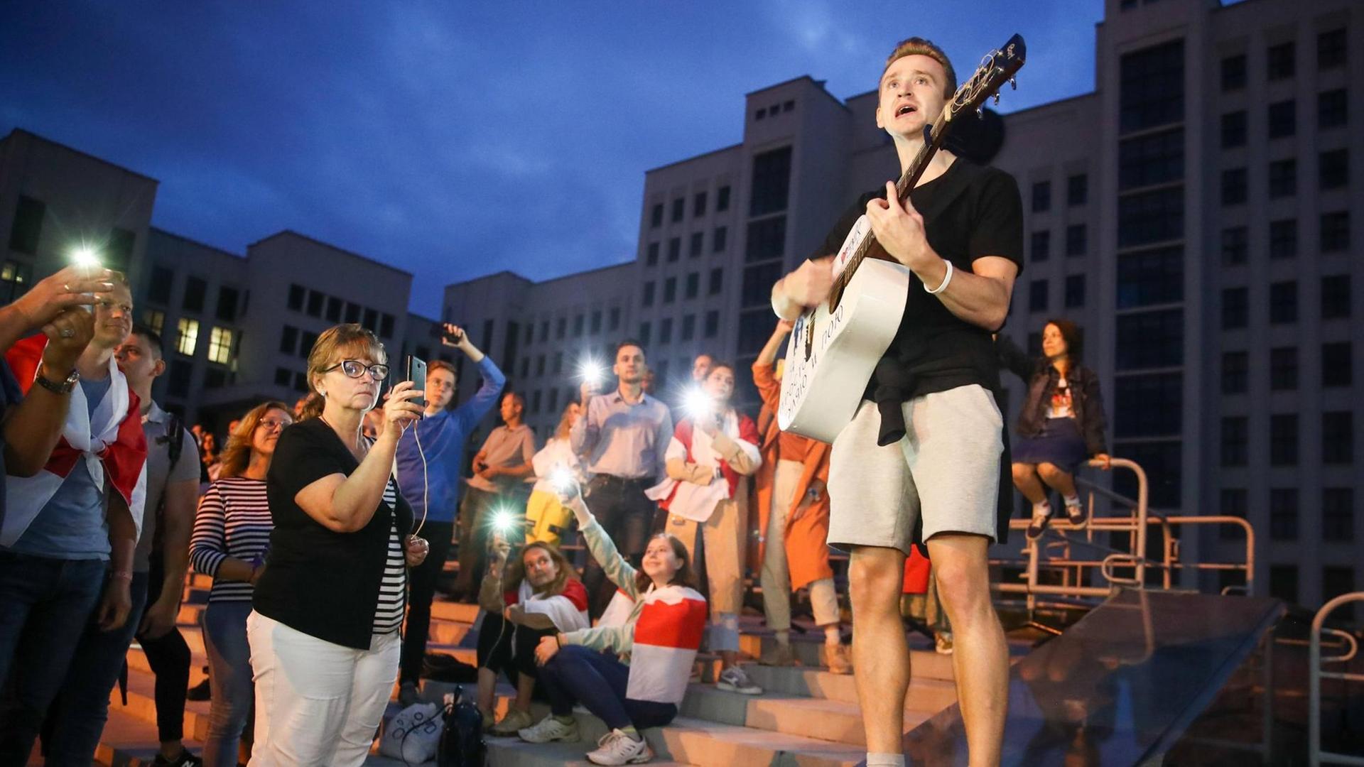 Ein junger Gitarrist gibt in Minsk abends auf einen Platz ein spontanes Konzert. Das Publikum macht Fotos, einige haben sich in die belarusische Fahne gewickelt. Valery Sharifulin/TASS PUBLICATIONxINxGERxAUTxONLY TS0E4073 Ein junger Gitarrist gibt in Minsk abends auf einen Platz ein spontanes Konzert. Das Publikum macht Fotos, einige haben sich in die belarusische Fahne gewickelt. Valery Sharifulin/TASS PUBLICATIONxINxGERxAUTxONLY TS0E4073