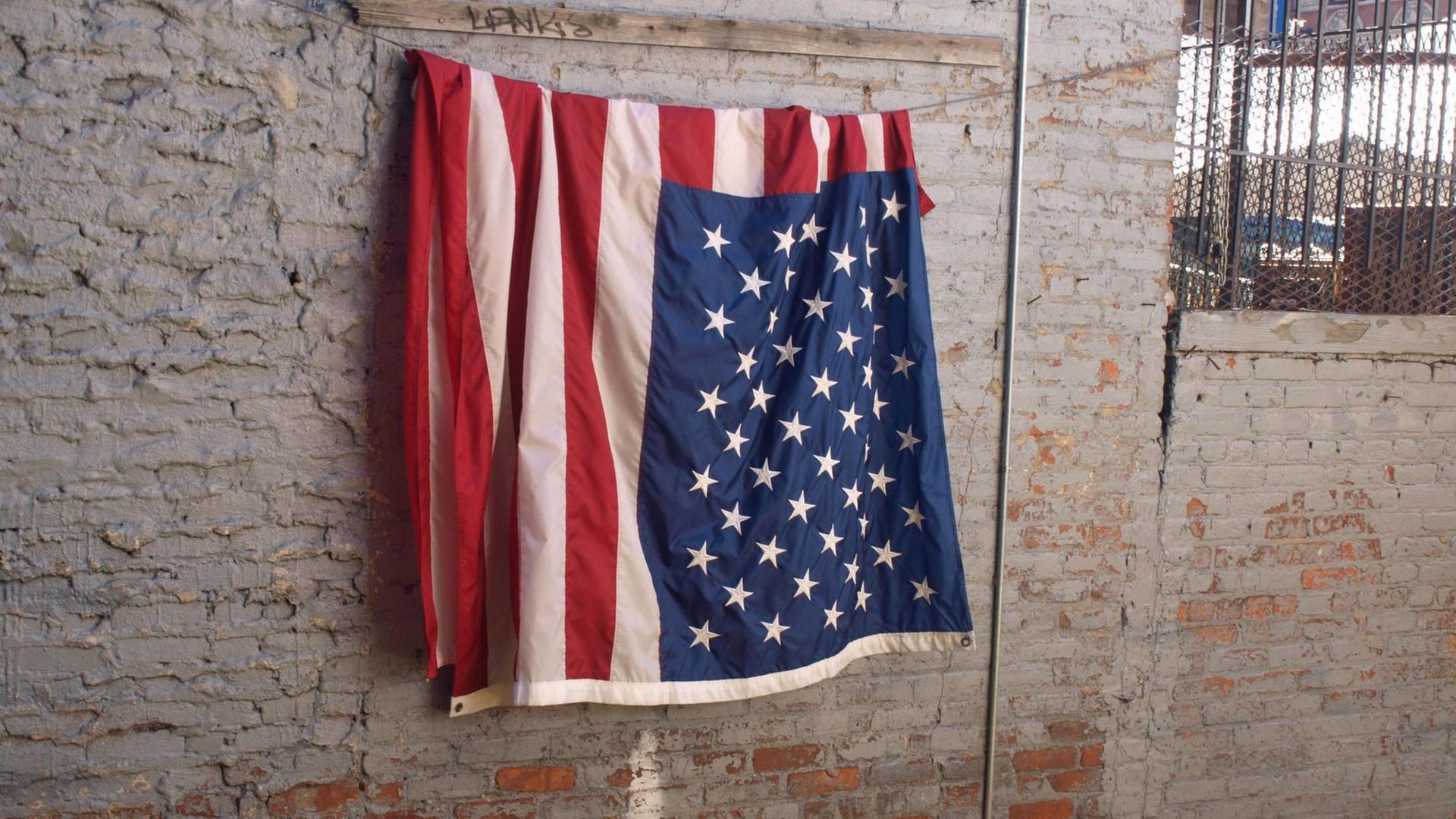 Flagge der USA hängt an einer Wand in New York Flagge der USA hängt an einer Wand in New York