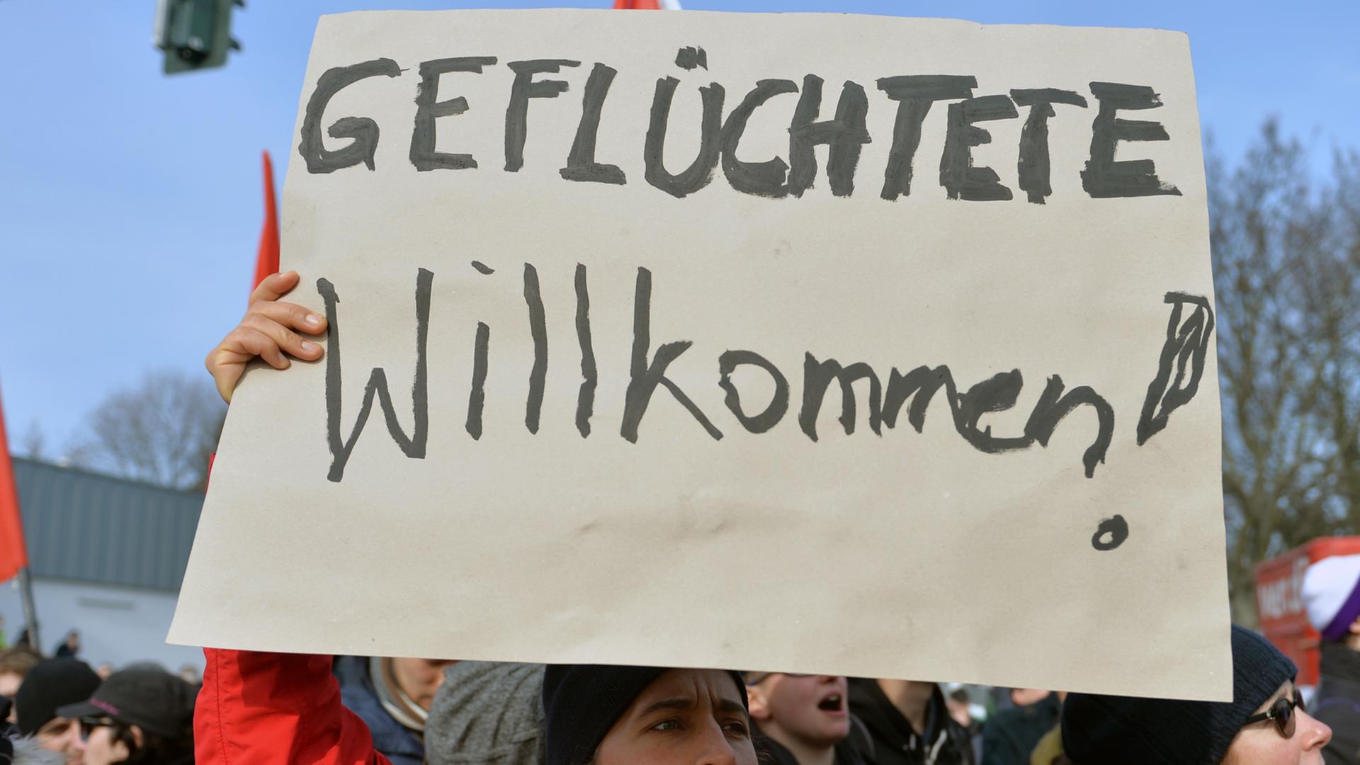 "Geflüchtete Willkommen" steht auf dem Plakat einer Demonstrantin. "Geflüchtete Willkommen" steht auf dem Plakat einer Demonstrantin.