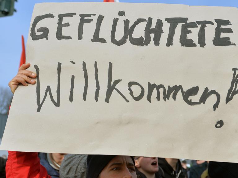 "Geflüchtete Willkommen" steht auf dem Plakat einer Demonstrantin.