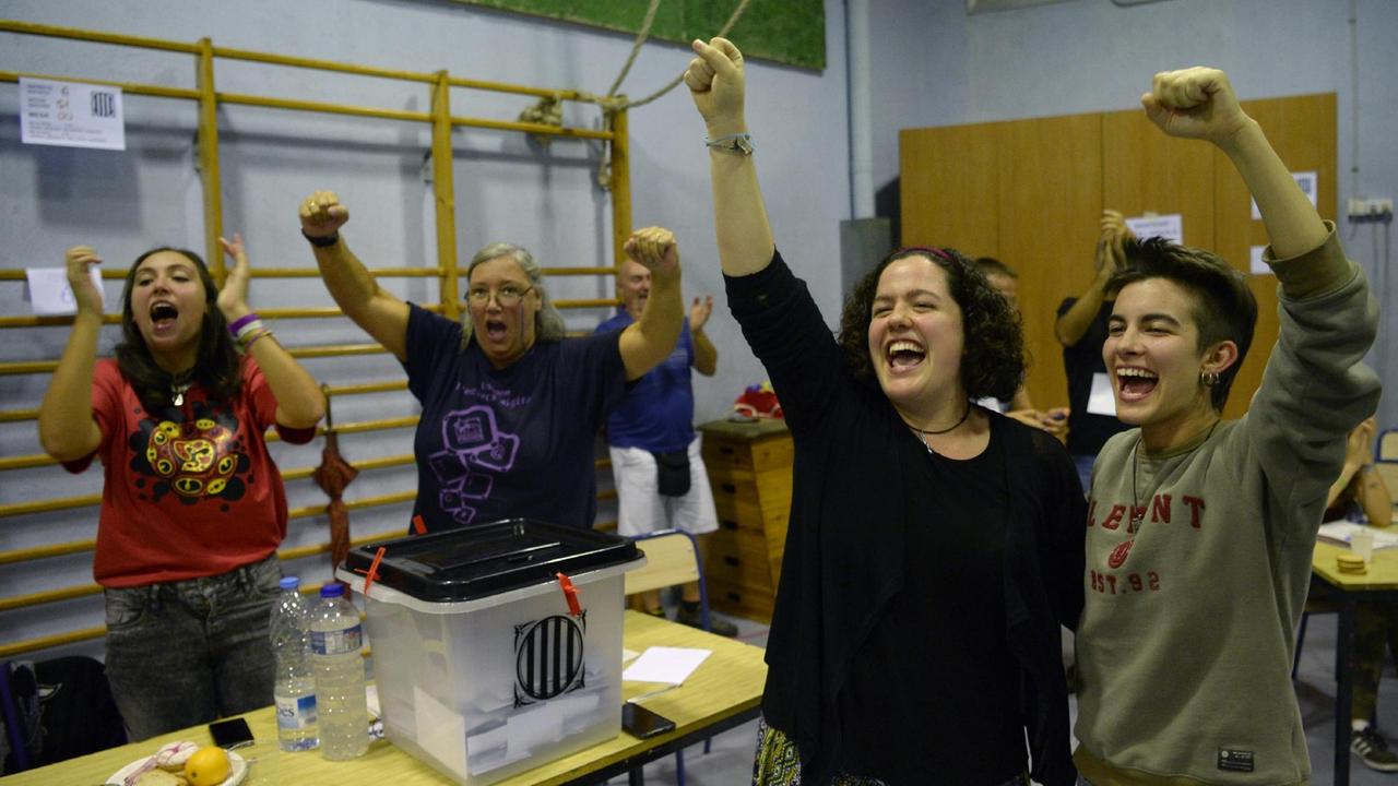 Menschen jubeln in einem Wahllokal in Barcelona. Menschen jubeln in einem Wahllokal in Barcelona.