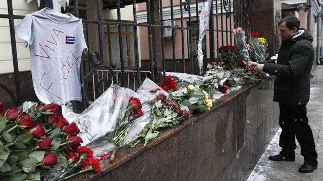 Ein Mann legt vor der kubanischen Botschaft in Moskau Blumen nieder.