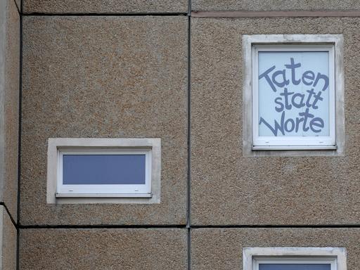 "Taten statt Worte" steht an einem Abrisshaus im sächsischen Hoyerswerda.