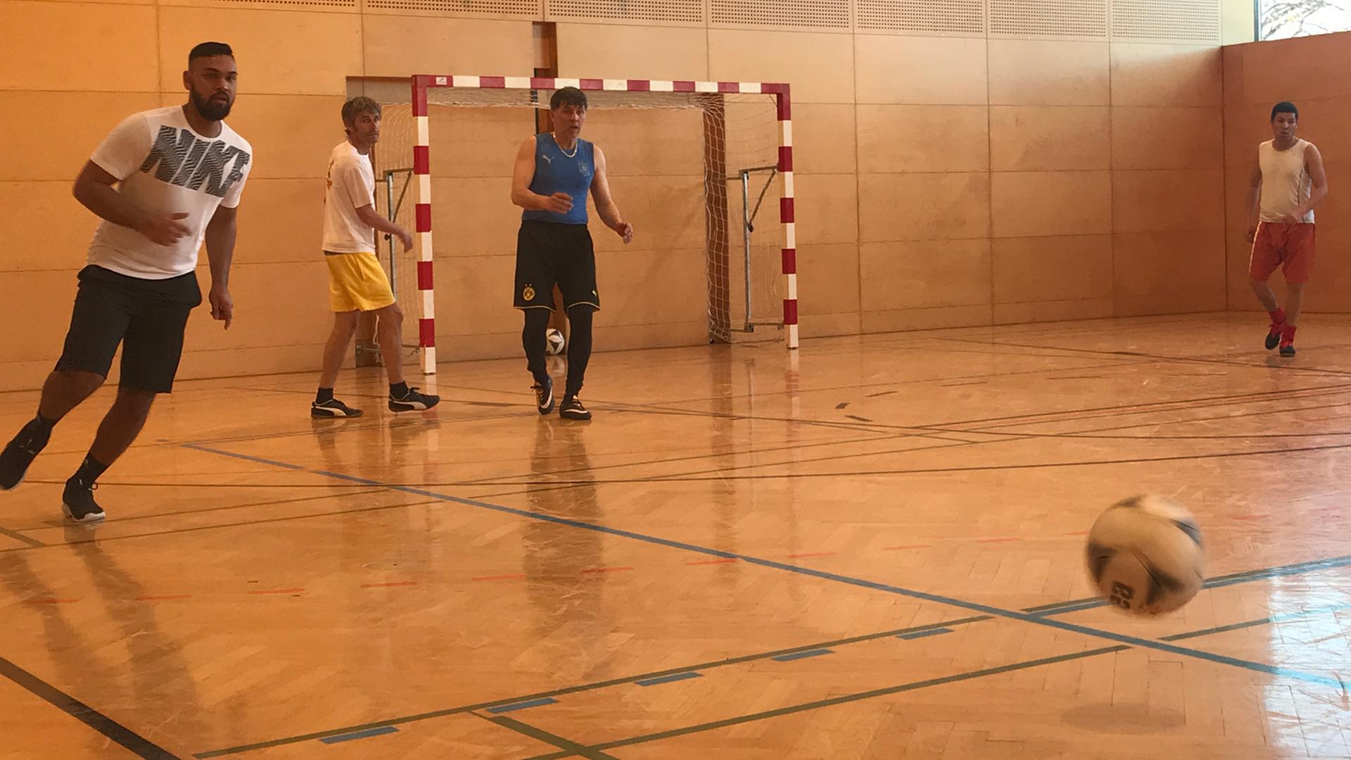 Die Spieler des "FC International" spielen in einer Turnhalle Fußball. Die Spieler des "FC International" spielen in einer Turnhalle Fußball.
