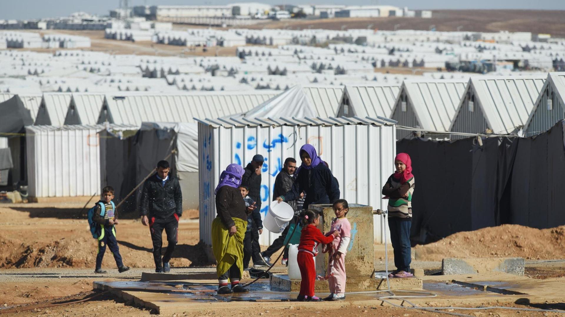 Frauen und Kinder vor den Hütten des UNHCR.Flüchtlingslagers in Azraq in Jordanien. Frauen und Kinder vor den Hütten des UNHCR.Flüchtlingslagers in Azraq in Jordanien.