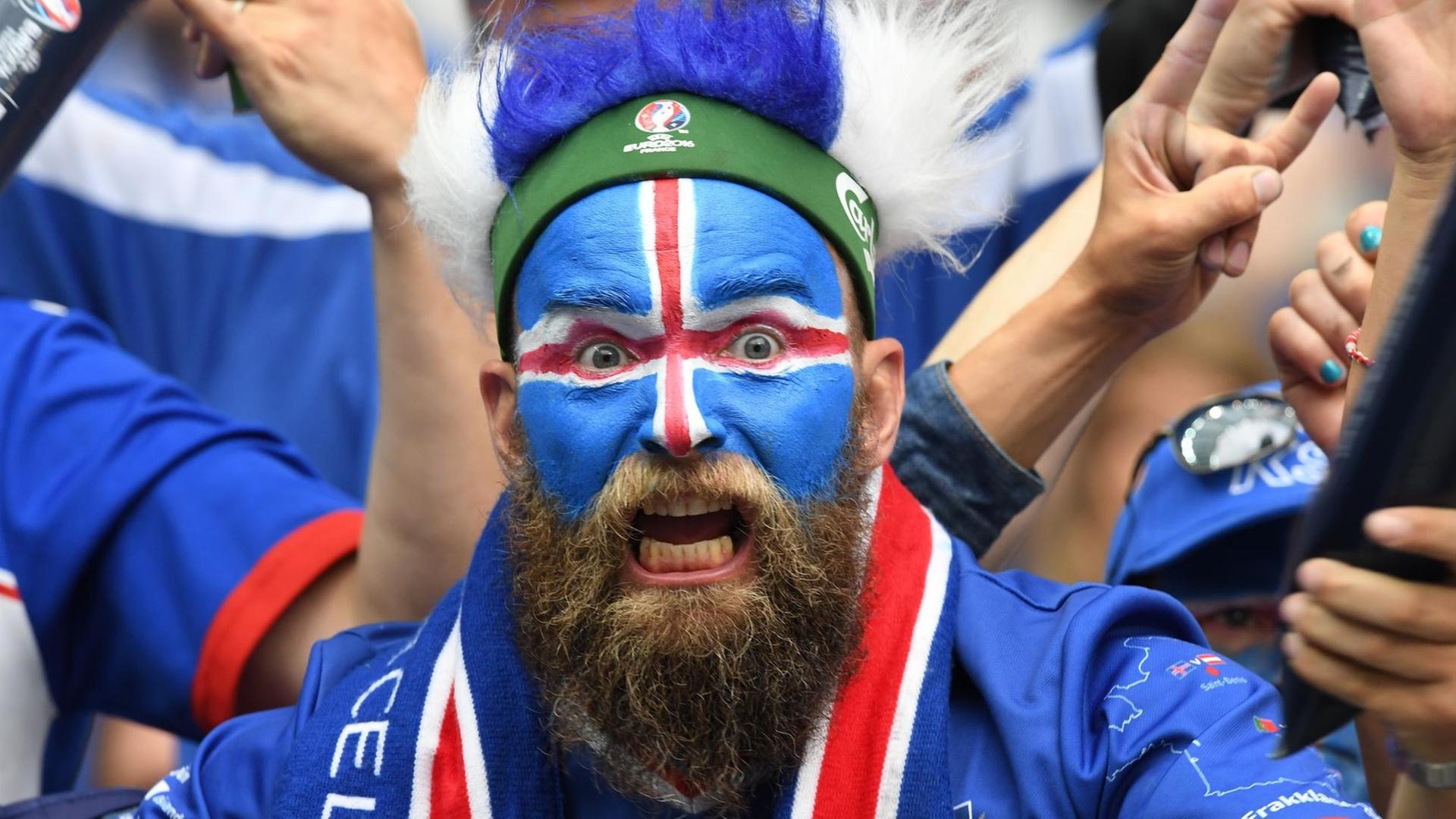 Ein isländischer Fan, bunt bemalt und mit Perücke.
