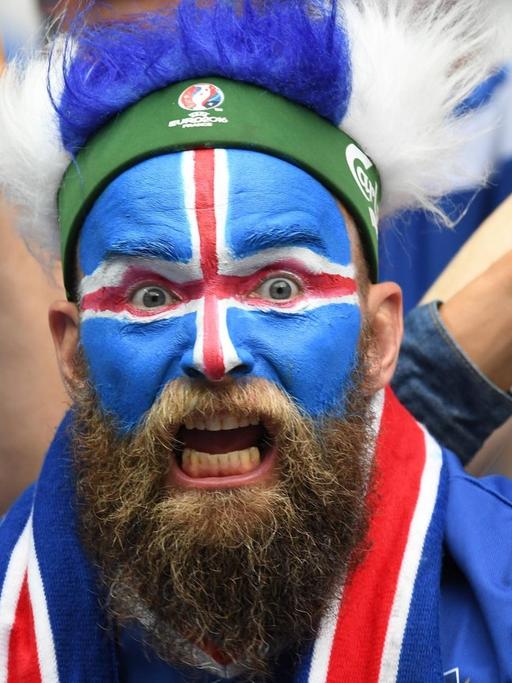 Ein isländischer Fan, bunt bemalt und mit Perücke.
