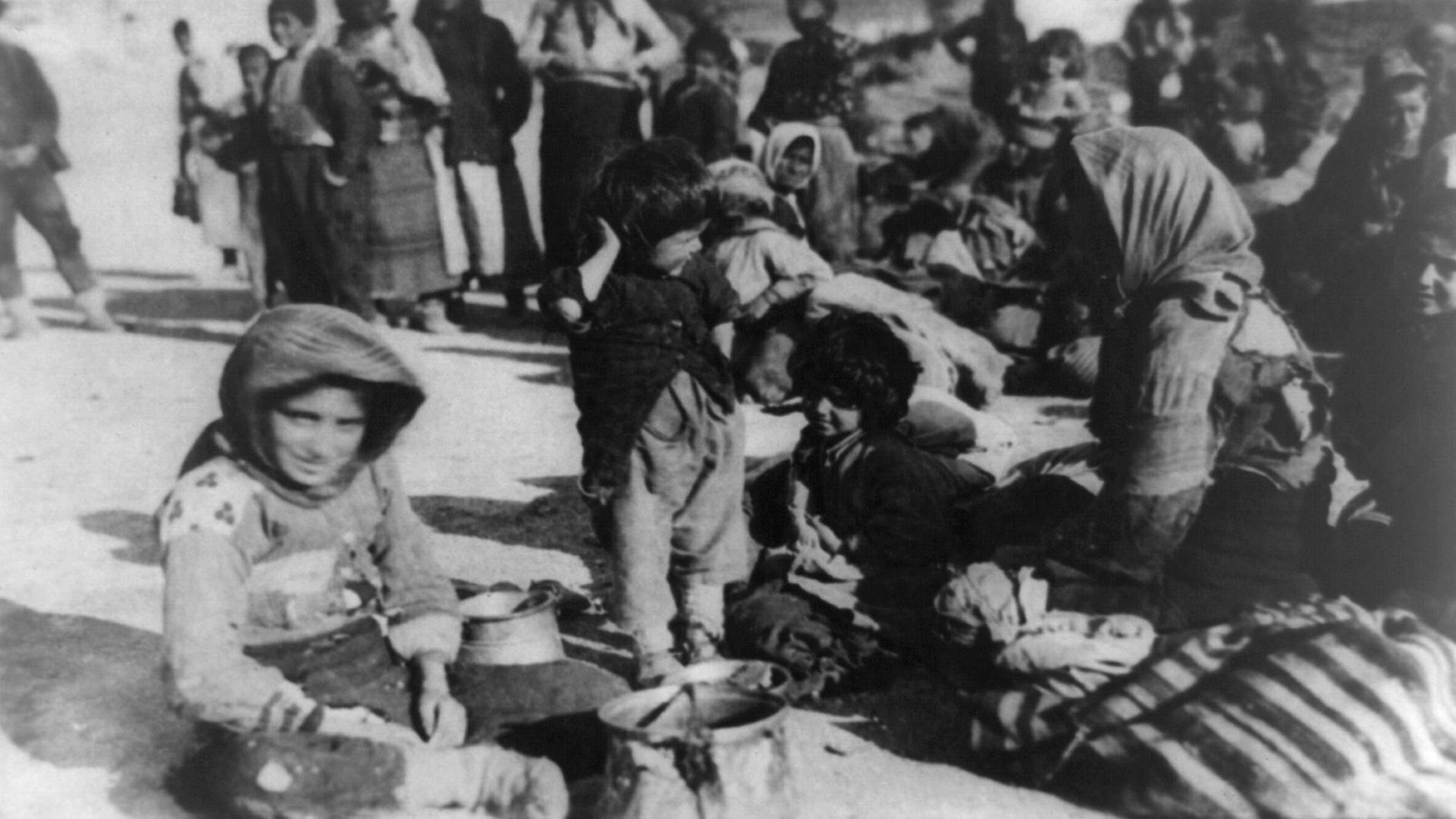Eine Gruppe armenischer Flüchtlinge aus dem osmanischen Reich sitzt im Jahr 1915 in Syrien auf dem Boden.