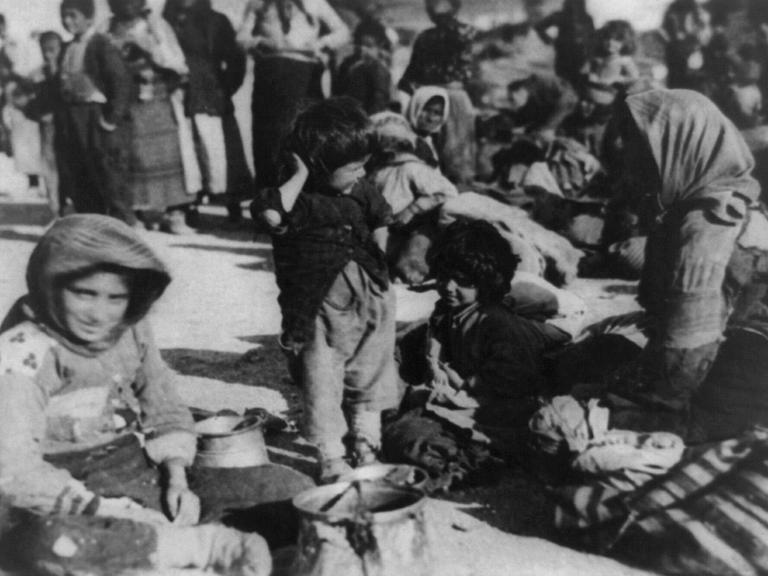 Eine Gruppe armenischer Flüchtlinge aus dem osmanischen Reich sitzt im Jahr 1915 in Syrien auf dem Boden.