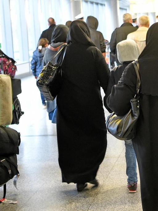 Syrische Flüchtlinge gehen am 04.04.2016 durch die Ankunfthalle B auf dem Flughafen Hannover (Niedersachsen). Es sind die ersten syrischen Flüchtlinge, die legal auf direktem Weg aus der Türkei in die Europäische Union einreisen durften.