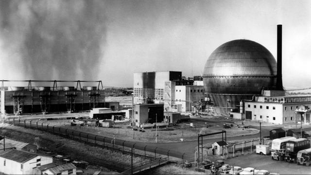 Blick auf das Atomkraftwerk Windscale, Großbritannien, 14.04.1963. Gut zu erkennen sind die vier Kühltürme links, die Turbinenhalle in der Mitte und das runde aluminiumverkleidete "Containment"-Gebäude rechts. Die Atomanlage wurde vor allem durch zahlreiche nukleare Störfälle bekannt. Der schwerste davon, ein Feuer bei dem eine Wolke mit radioaktivem Material freigesetzt wurde, ereignete sich am 10.10.1957. Im Jahre 1981 wurde die Anlage in Sellafield umbenannt. |