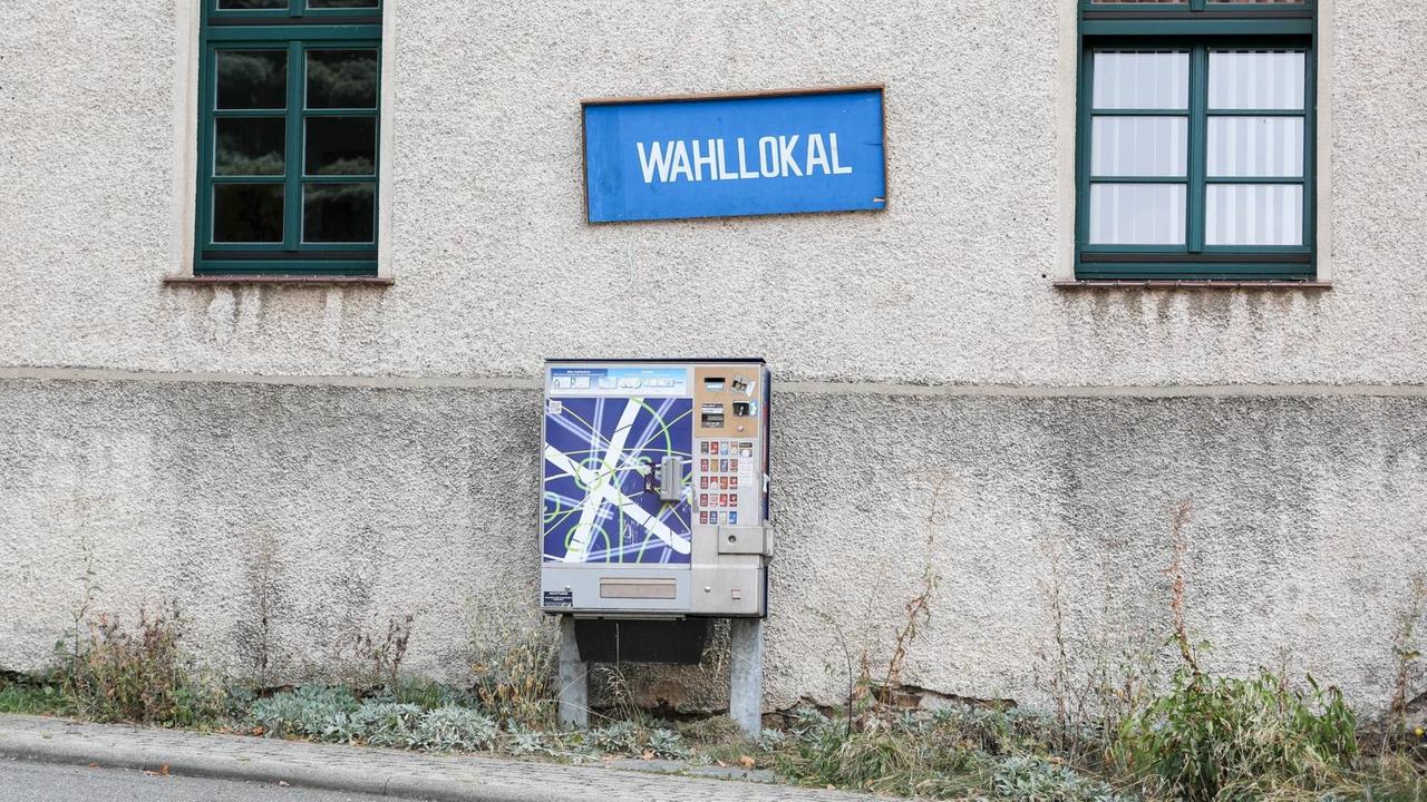 In dem sächsischen Ort Cannewitz hängt an einer Hauswand ein blaues Schild mit der weißen Aufschrift "Wahllokal". Darunter ist ein Zigarettenautomat. In dem sächsischen Ort Cannewitz hängt an einer Hauswand ein blaues Schild mit der weißen Aufschrift "Wahllokal". Darunter ist ein Zigarettenautomat.