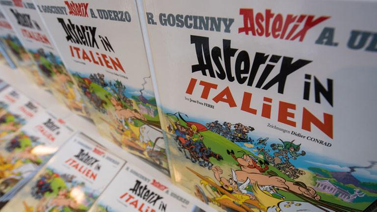 Neue Bände des Comics "Asterix in Italien" liegen am 19.10.2017 in Stuttgart (Baden-Württemberg) in der Buchhandlung Wittwer in einem Regal. (zu dpa "«Schatz, die Orgie wird kalt!» Der neue «Asterix» ist da" vom 19.10.2017) Foto: Marijan Murat/dpa