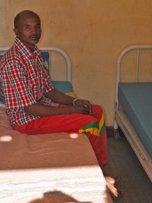 Ein Mann sitzt auf einem Bett im einzigen psychiatrischen Krankenhaus Madagaskars.