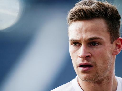 Der Fußballer Joshua Kimmich (FC Bayern) in einem weißen Trikot, hat den Mund halb geöffnet und schaut mit gerunzelter Stirn in die Ferne