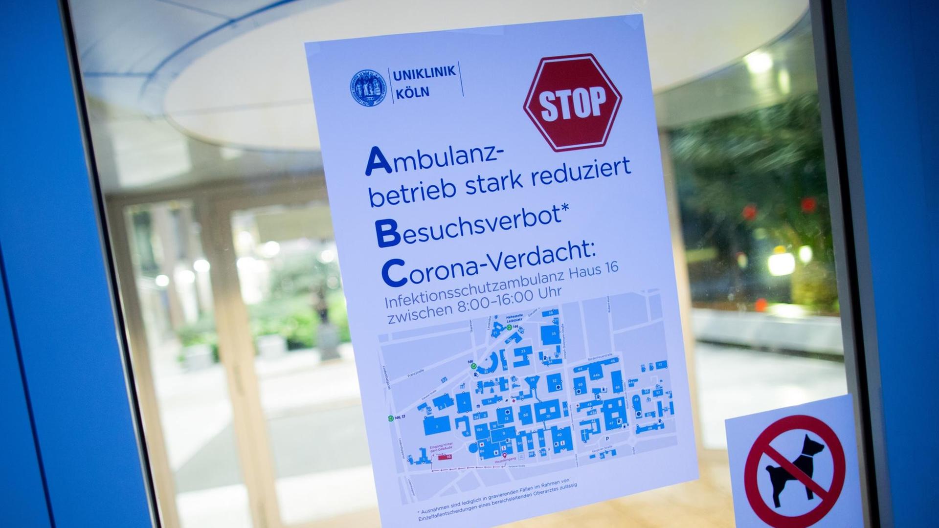 Blick auf den Haupteingang zur Uniklinik Köln. Ein Hinweisschild weist auf einen stark reduzierten Ambulanzbetrieb hin Blick auf den Haupteingang zur Uniklinik Köln. Ein Hinweisschild weist auf einen stark reduzierten Ambulanzbetrieb hin