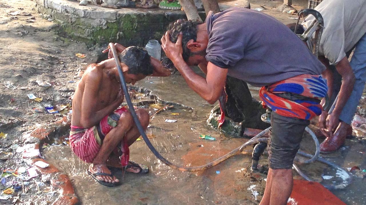 Obdachlose waschen sich auf der Straße, Neu Delhi, Indien. Obdachlose waschen sich auf der Straße, Neu Delhi, Indien.
