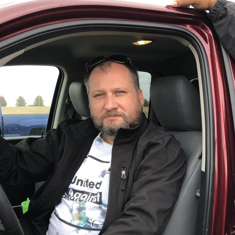 TM Garret, früher bekannt als Achim Schmid, sitzt in einem Auto TM Garret, früher bekannt als Achim Schmid, sitzt in einem Auto