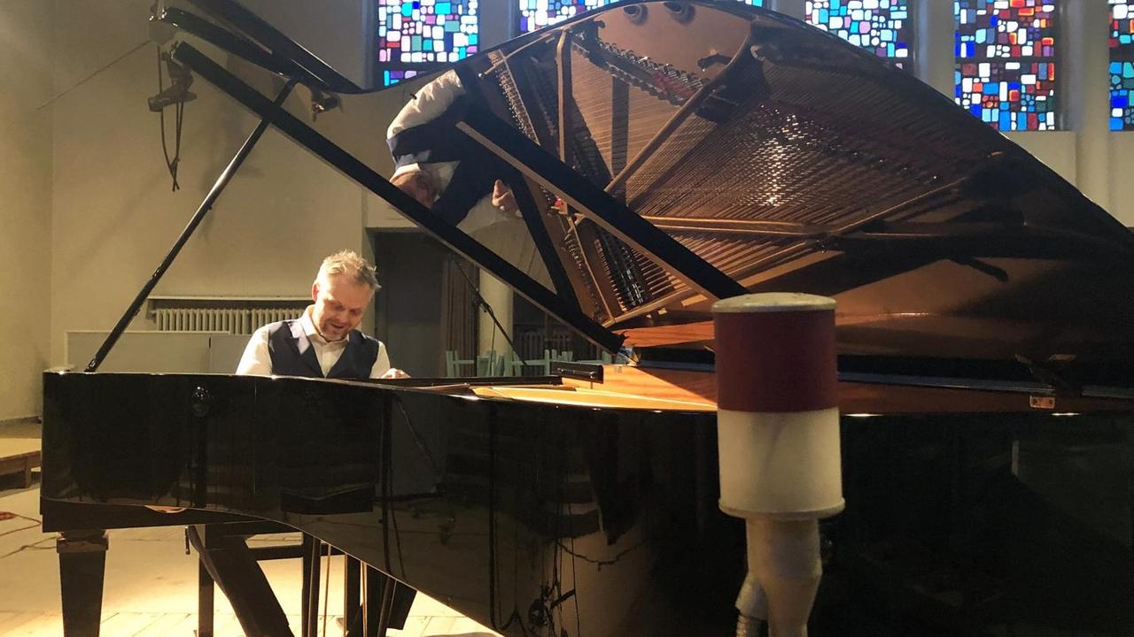 Der Pianist sitzt am Flügel und drumherum befinden sich Mikrofone. Der Pianist sitzt am Flügel und drumherum befinden sich Mikrofone.
