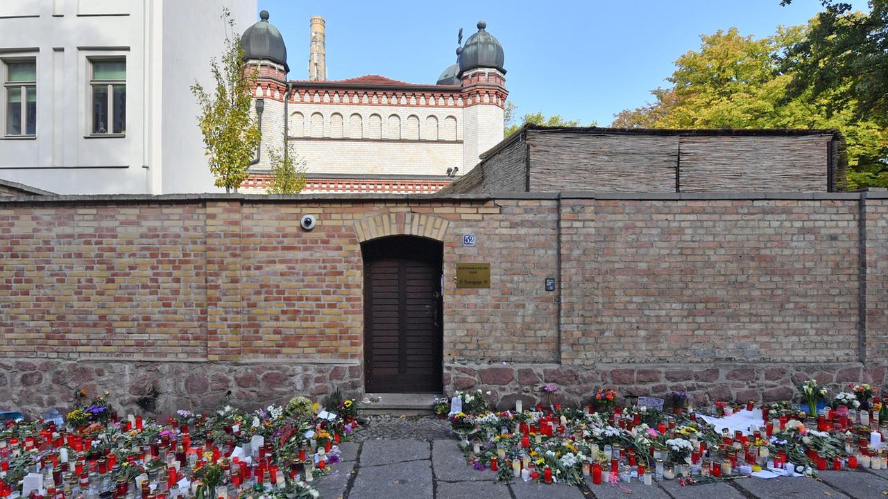 Blumen und Kerzen stehen in Halle neben der Tür zur Synagoge, vier Tage nach dem rechtsextremistischen Anschlag auf die Gemeinde Blumen und Kerzen stehen in Halle neben der Tür zur Synagoge, vier Tage nach dem rechtsextremistischen Anschlag auf die Gemeinde