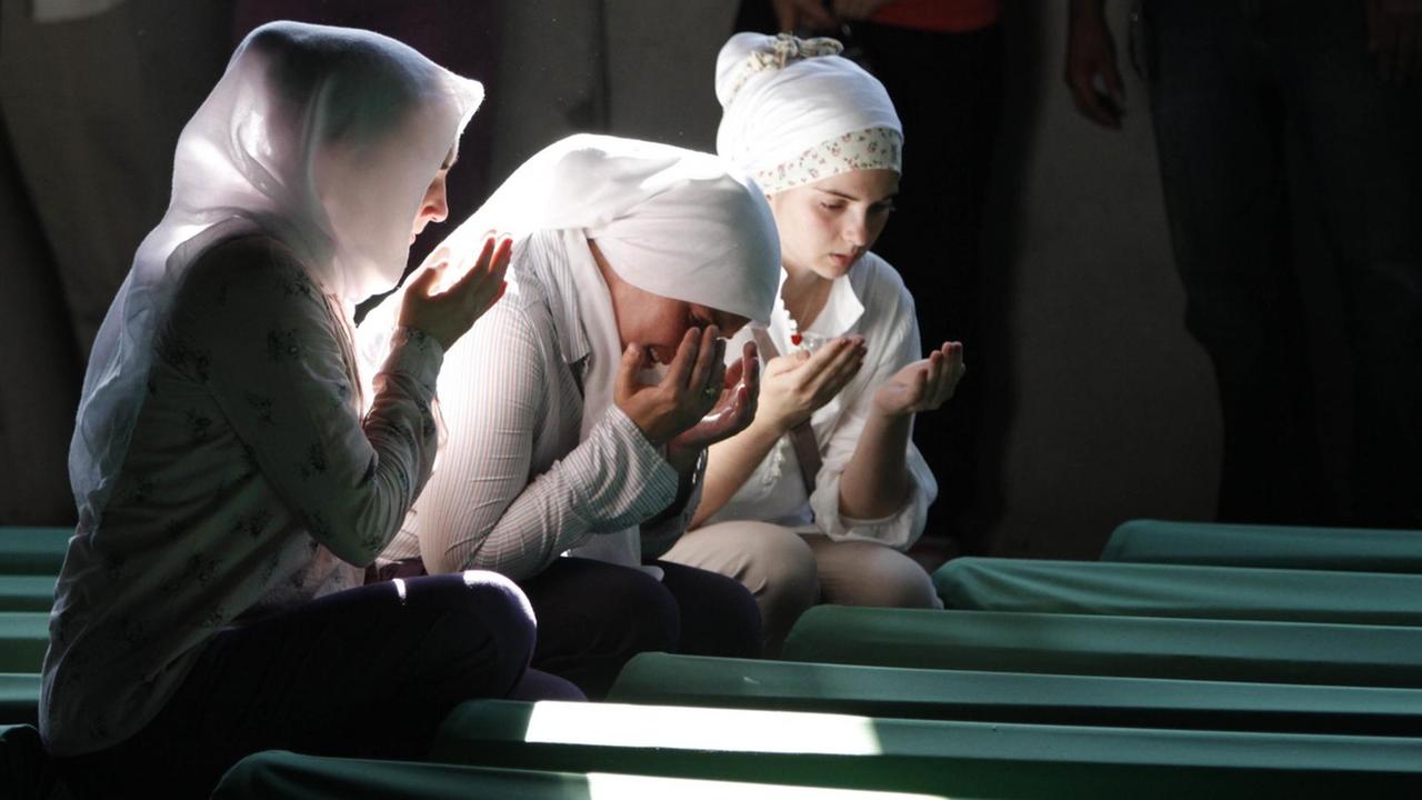 Bosnische Muslimas beten in Potocari (Bosnien) vor Särgen von Opfern des Massakers von Srebrenica die in einer Gedenkstätte aufgestellt wurden. Bosnische Muslimas beten in Potocari (Bosnien) vor Särgen von Opfern des Massakers von Srebrenica die in einer Gedenkstätte aufgestellt wurden.