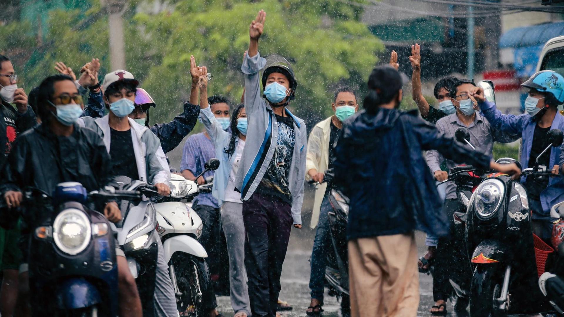 Menschen auf Rollern protestieren im Regen in Mandalya, Myanmar, im Juni 2021 Menschen auf Rollern protestieren im Regen in Mandalya, Myanmar, im Juni 2021