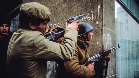 Rumänische Soldaten mit Waffen im Anschlag in den Straßen von Bukarest im Dezember 1989
