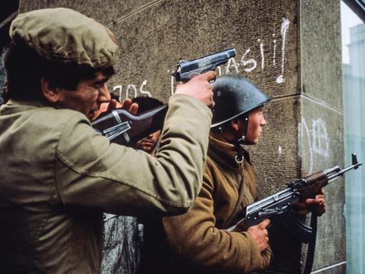 Rumänische Soldaten mit Waffen im Anschlag in den Straßen von Bukarest im Dezember 1989