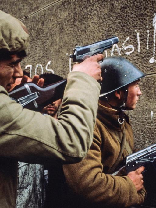 Rumänische Soldaten mit Waffen im Anschlag in den Straßen von Bukarest im Dezember 1989