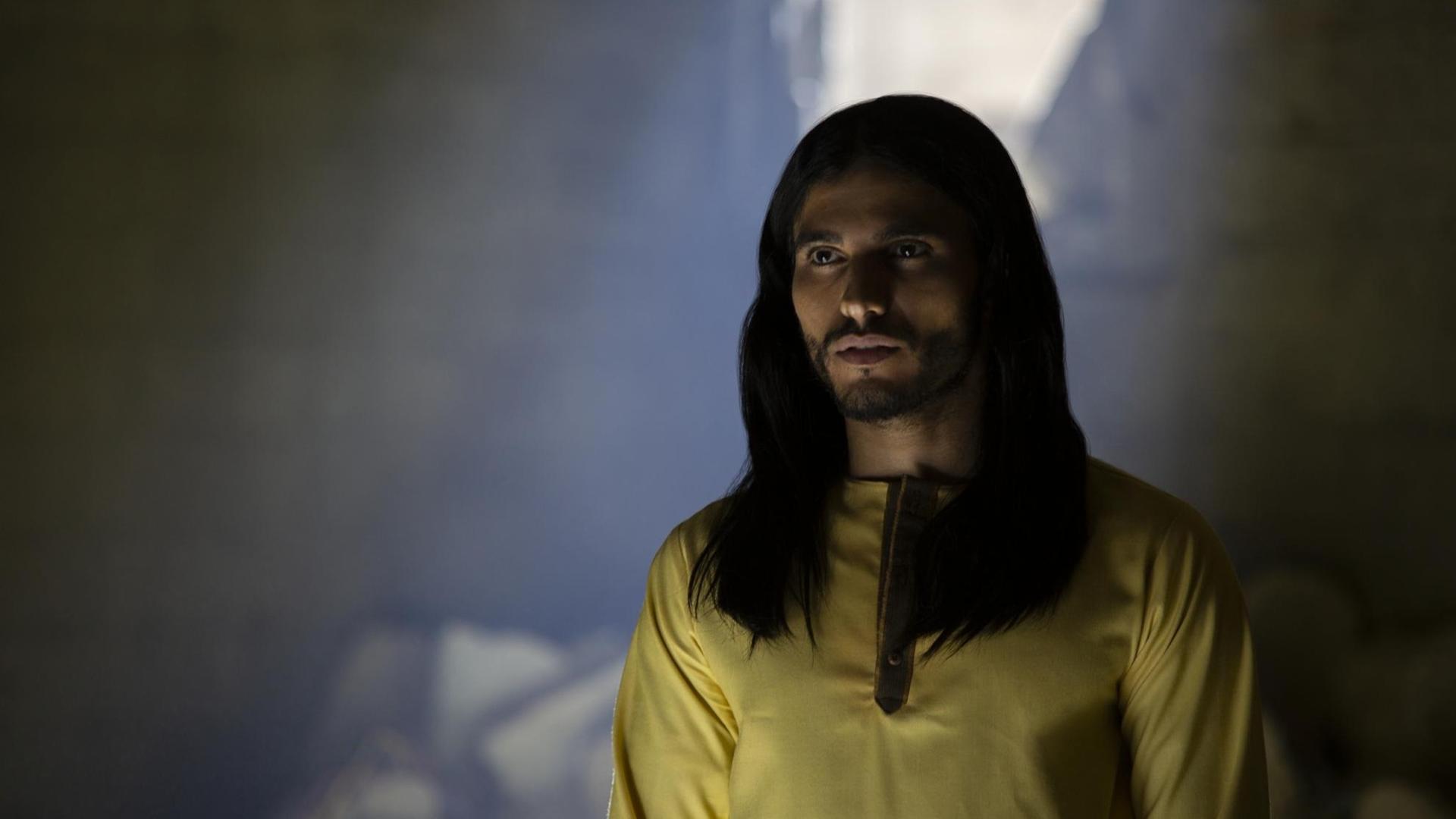 Eine Filmszene aus der Netflix Serie "Messiah" zeigt selbigen in gelbem Hemd, langer Mähne und Bart. Eine Filmszene aus der Netflix Serie "Messiah" zeigt selbigen in gelbem Hemd, langer Mähne und Bart.