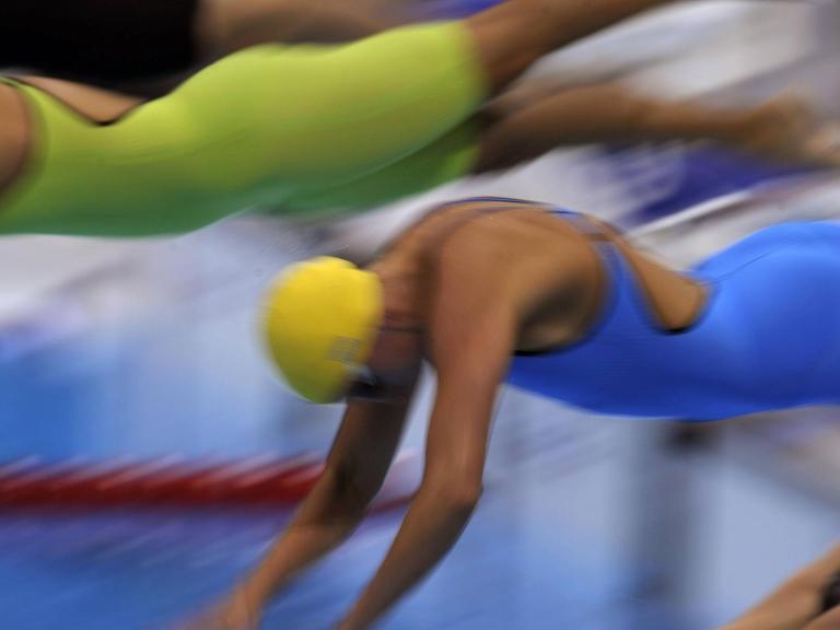 Schwimmerinnen bei den Olympischen Spielen in London springen ins Becken.