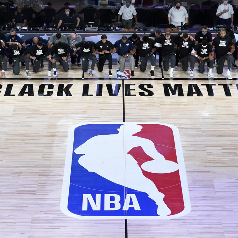 Die Spieler der New Orleans Pelicans und von Utah Jazz knien während dem Abspielen der Nationalhymne gemeinsam vor einem «Black Lives Matter»-Schriftzug.