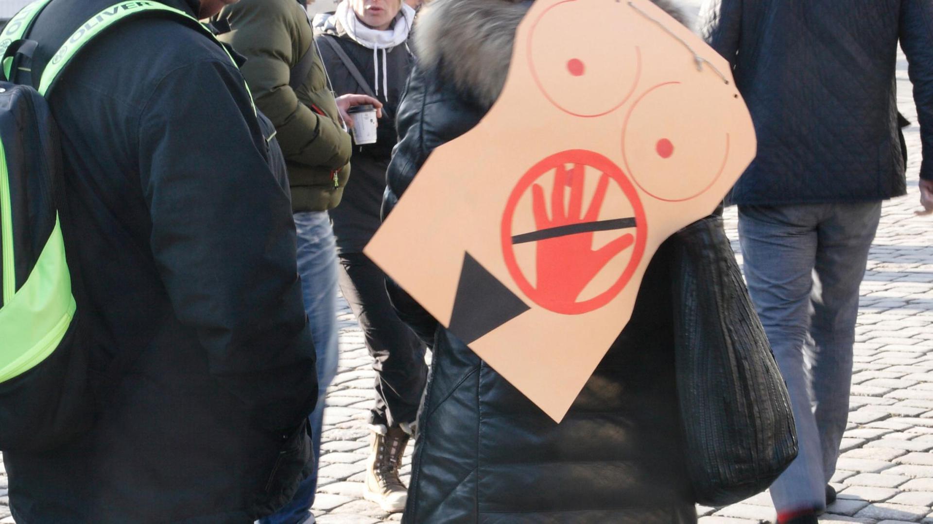 In Dresden auf dem Neumarkt trägt eine Frau auf einer Veranstaltung auf dem Ruecken ein symbolisches Bild gegen sexuelle Belästigung oder sexuelle Uebergriffe In Dresden auf dem Neumarkt trägt eine Frau auf einer Veranstaltung auf dem Ruecken ein symbolisches Bild gegen sexuelle Belästigung oder sexuelle Uebergriffe