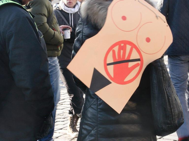 In Dresden auf dem Neumarkt trägt eine Frau auf einer Veranstaltung auf dem Ruecken ein symbolisches Bild gegen sexuelle Belästigung oder sexuelle Uebergriffe