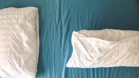 Zwei Kopfkisen liegen auf einem Bett