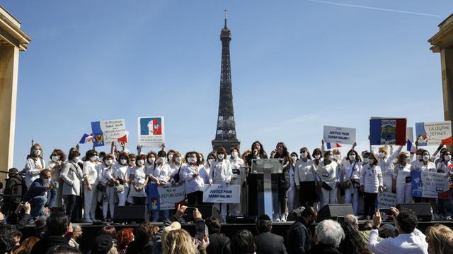 In Vordergrund Demonstranten, im Hintergrund ist der Eiffelturm zu sehen.